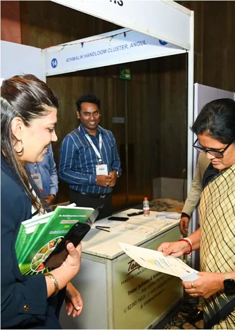 Delegates reviewing materials at an exhibition booth.