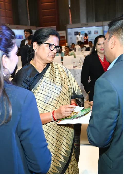 Delegates in conversation at an exhibition booth.
