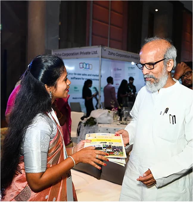 A delegate receiving a welcome kit at the registration desk.