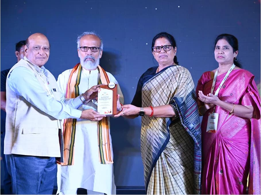 A dignitary presenting a memento to guests on stage.